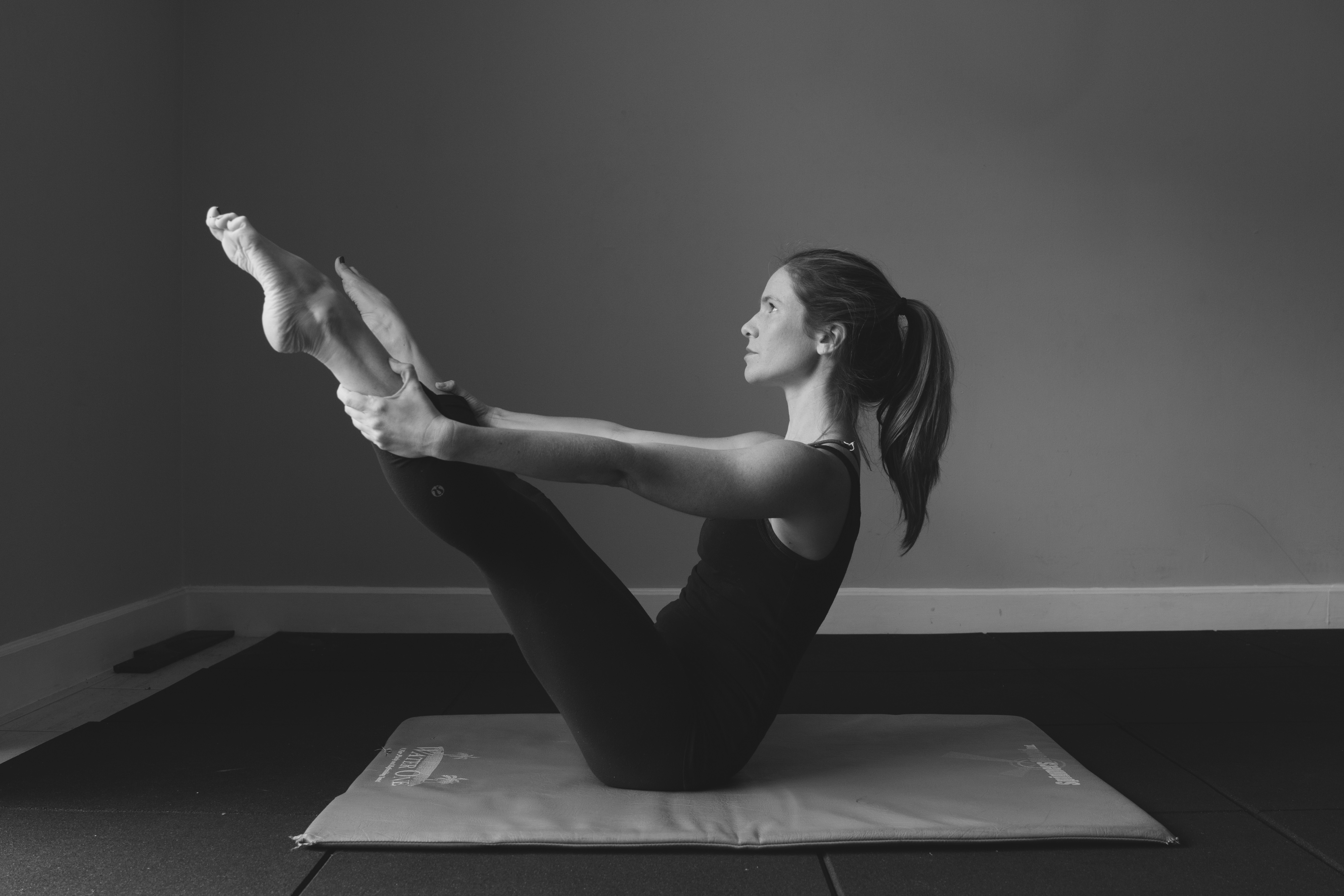 Melissa holding a strong Pilates Teaser pose